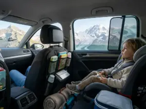 Kind auf dem Rücksitz bei einer Fahrt in die Berge
